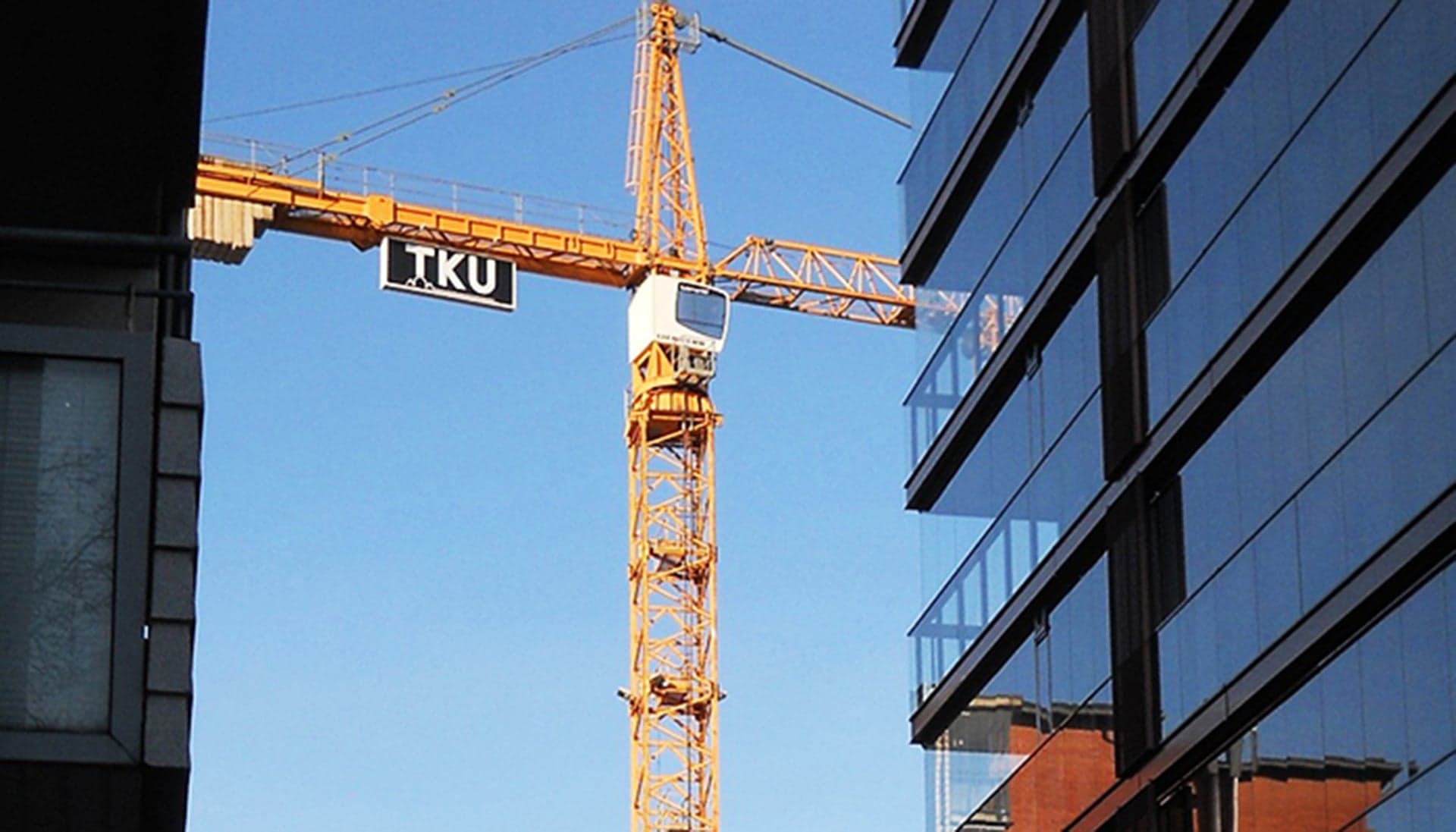 Skanska Rentalin torninosturi työmaalla siirtämässä materiaaleja turvallisesti